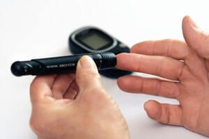 Close up photo of hands measuring blood sugar